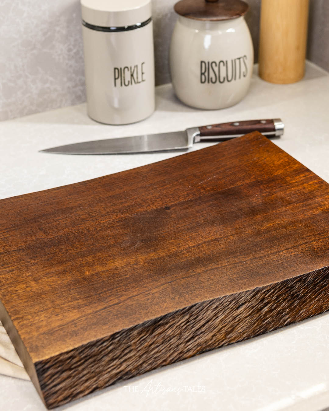 Wooden cutting board on a kitchen counter with a knife