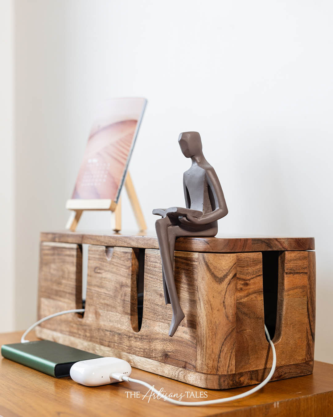 Wooden cable management box with a decorative figurine placed on top.